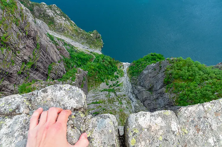 Hiker on Preikestolen hiking trail overlooking Lysefjord - TurCraft.com